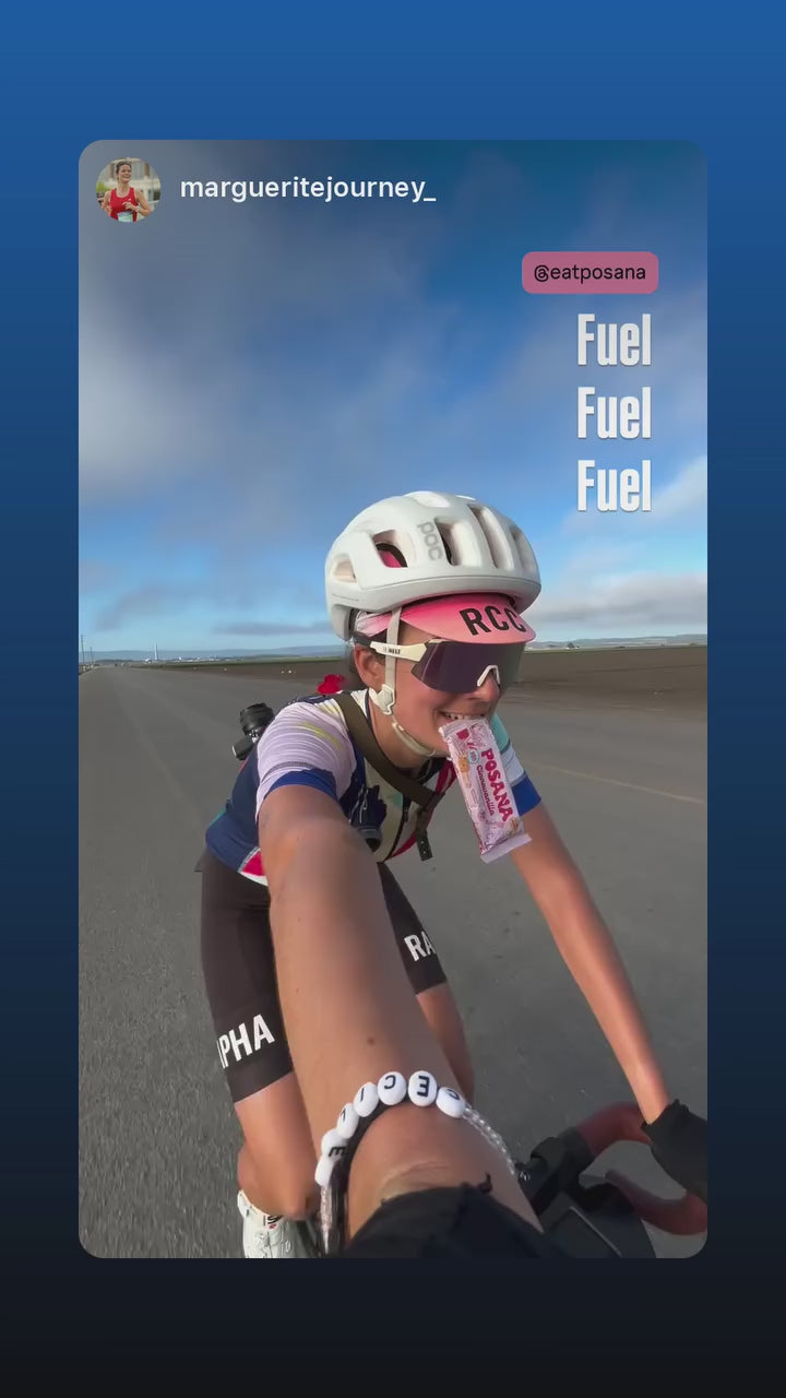 Cyclist eating a Posana bar mid-ride